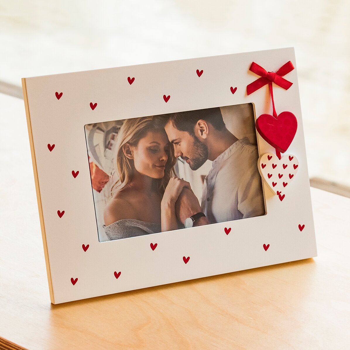 Cadre photo de bureau avec des petits cœurs et un nœud rouge, pour une photo